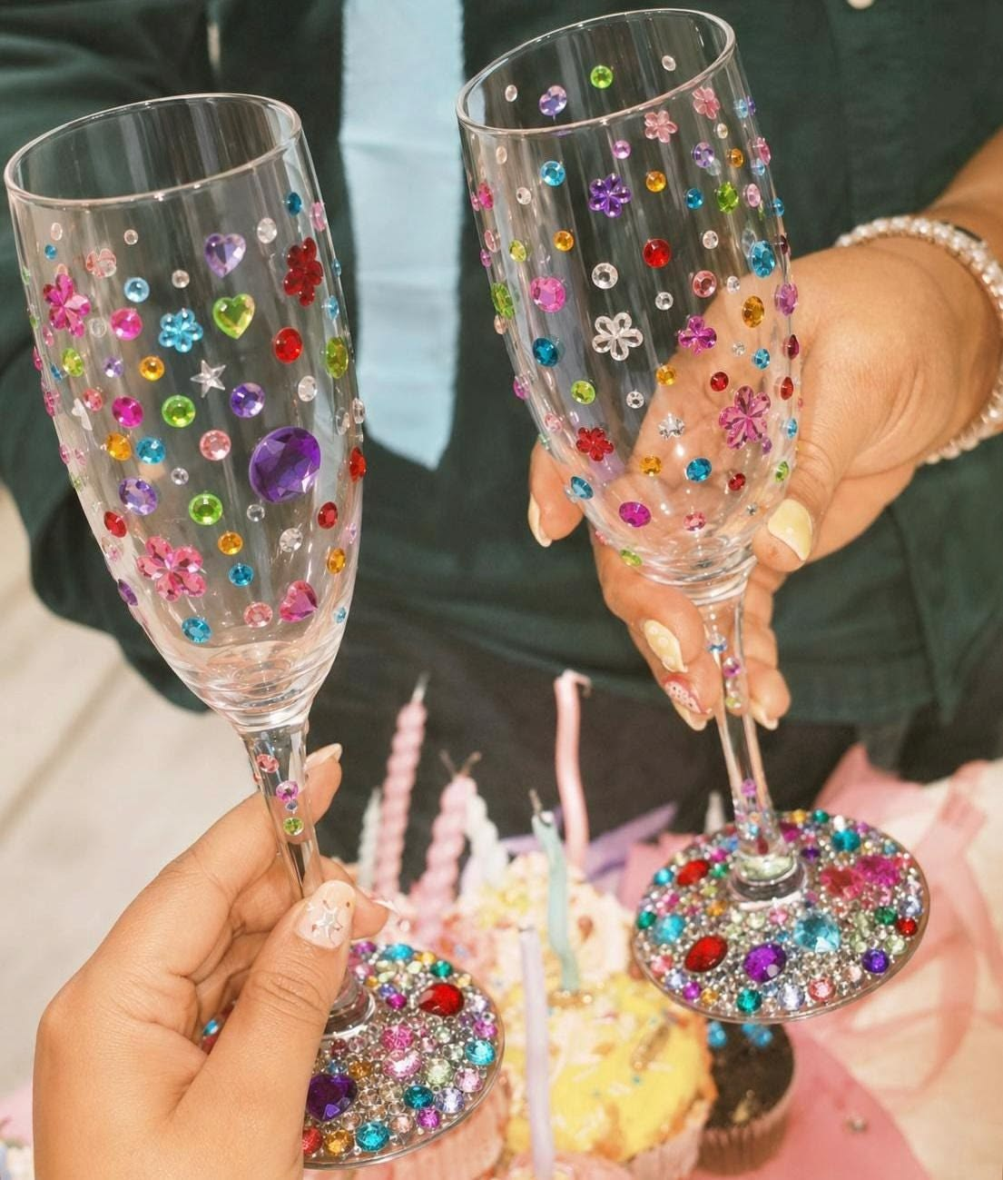 Colorful rhinestones decorating clear champagne glasses