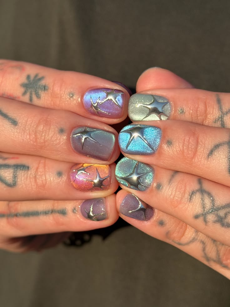 Cat eye holographic nail polish with star design on fingers