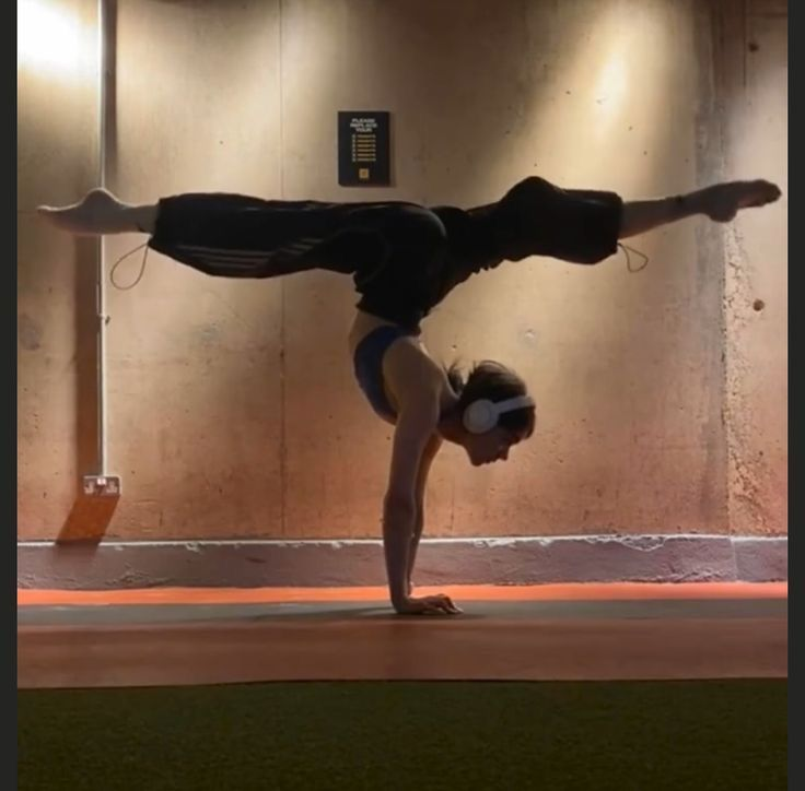 Woman doing a yoga handstand pose on a mat
