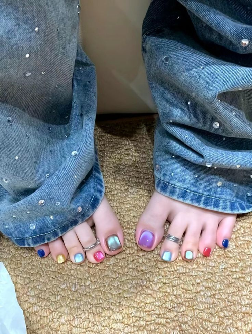 Colorful cat eye nail polish on toes with denim jeans