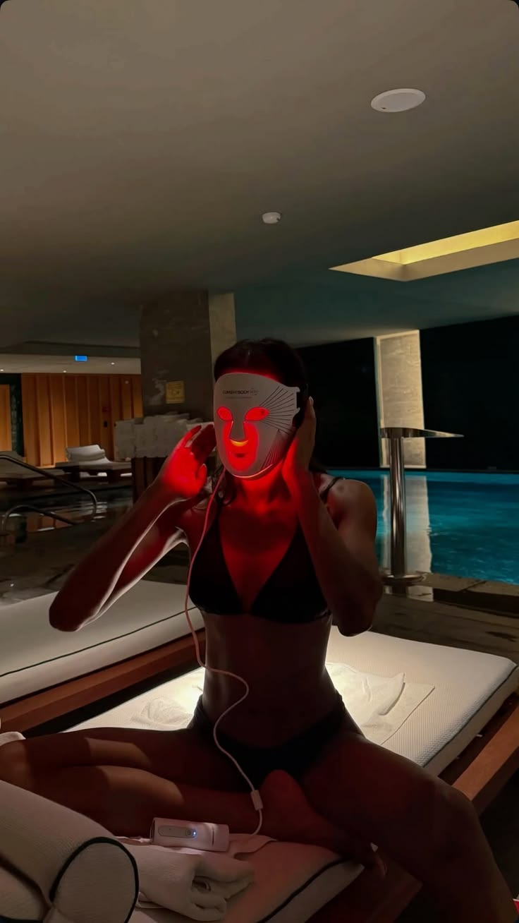 Person wearing a glowing red LED face mask during self-care