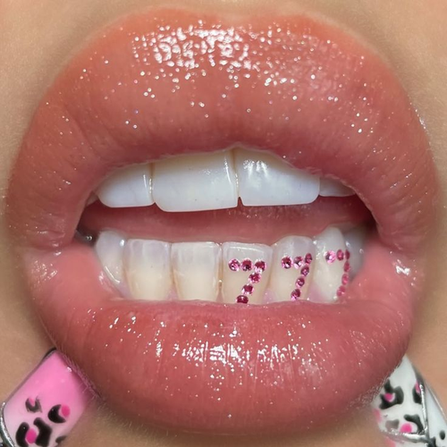 Pink tooth gems spelling a design on teeth
