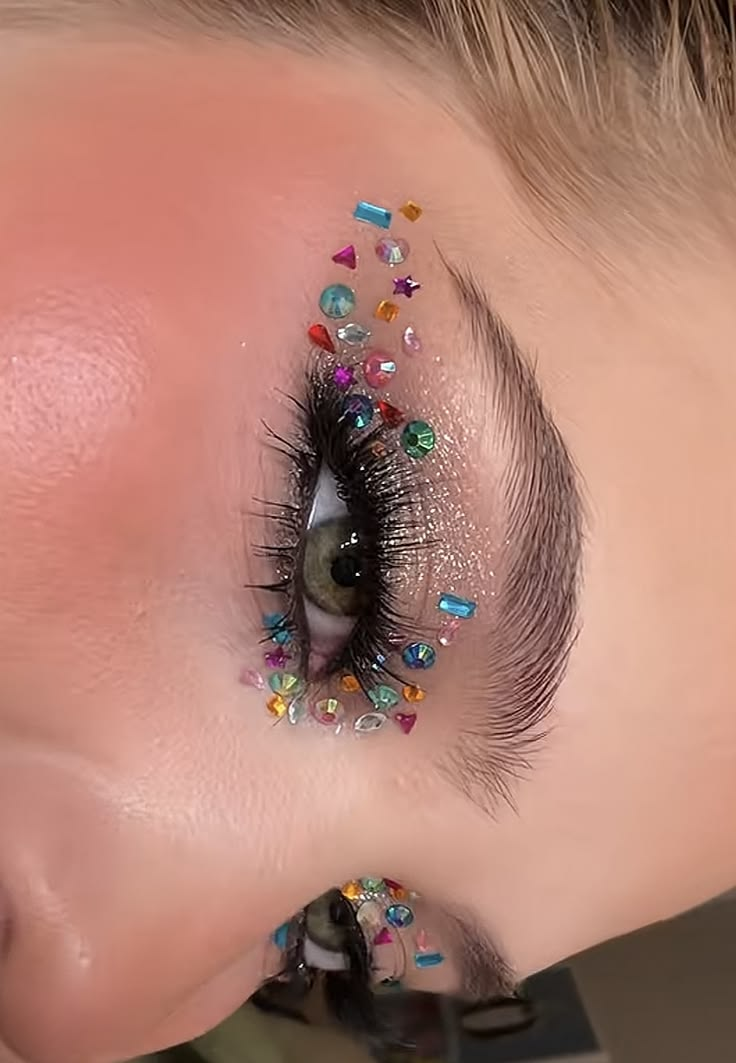 Colorful multi-shape rhinestones arranged around eye makeup
