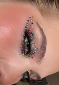 Colorful multi-shape rhinestones arranged around eye makeup