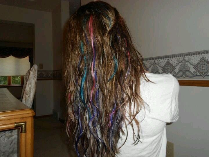 Colorful hair clip-in streaks styled in long brown hair